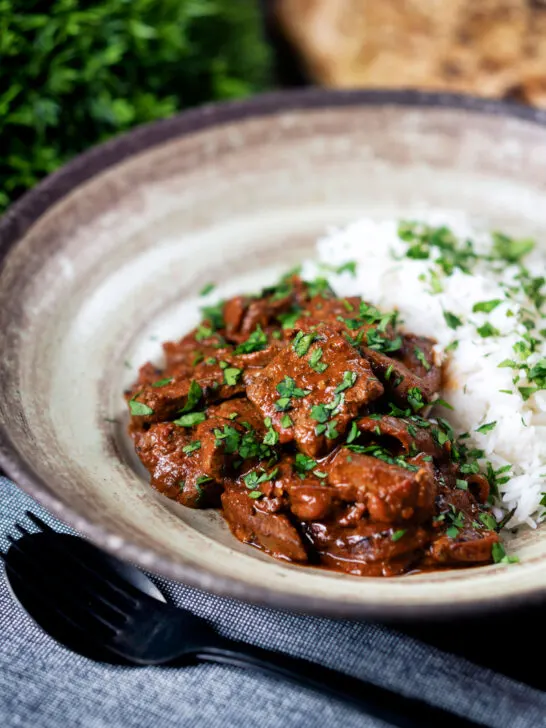 Kaleji masala or Indian lambs liver curry served with rice and naan bread.