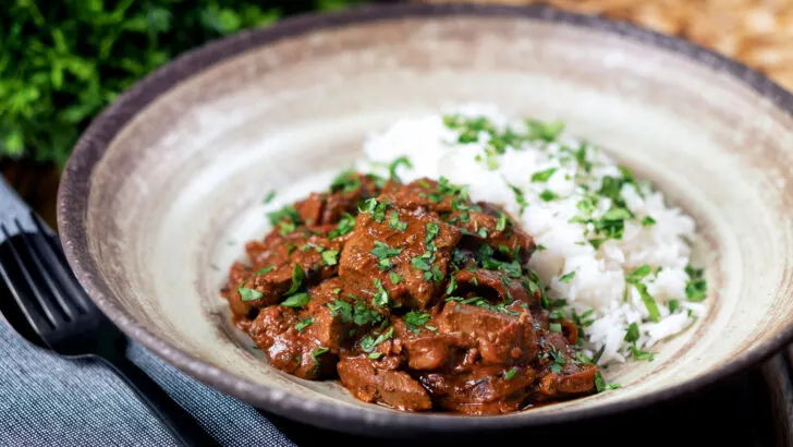 Indian lamb liver curry or kaleji masala served with rice, naan and fresh coriander.