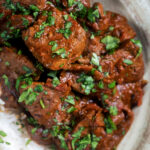 Overhead close-up kaleji masala or lambs liver curry serve with basmati rice.