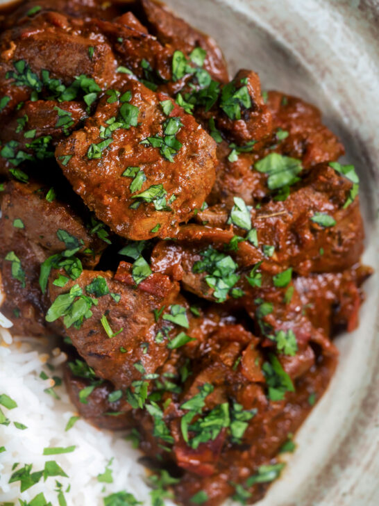 Overhead close-up kaleji masala or lambs liver curry serve with basmati rice.