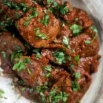 Overhead close-up kaleji masala or lambs liver curry serve with basmati rice featuring a title overlay.