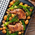 Overhead chicken leg tray bake with preserved lemon, shallot, potato, garlic and broccoli.