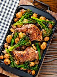 Overhead chicken leg tray bake with preserved lemon, shallot, potato, garlic and broccoli.