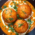Close-up overhead malai kofta, vegetarian paneer and potato "meatball" curry.