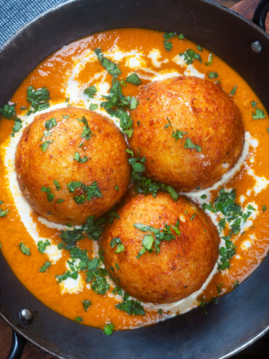 Close-up overhead malai kofta, vegetarian paneer and potato "meatball" curry.