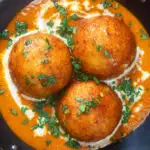 Close-up overhead malai kofta, vegetarian paneer and potato "meatball" curry featuring a title overlay.