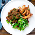 Overhead peri peri chicken livers served with beetroot salad and wedges,