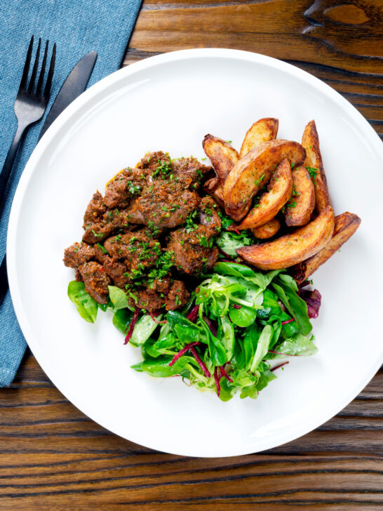 Overhead peri peri chicken livers served with beetroot salad and wedges,