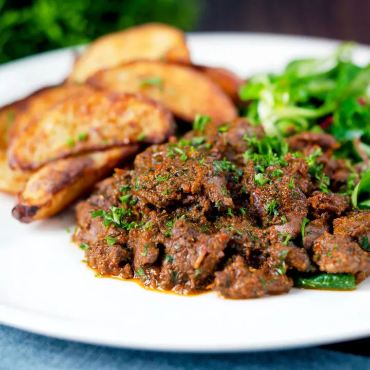 Spicy peri peri chicken livers served with salad leaves and potato wedges.