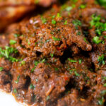 Close-up peri peri chicken livers served with beetroot salad and wedges.