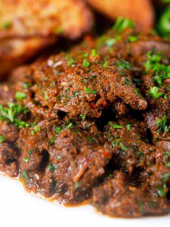 Close-up peri peri chicken livers served with beetroot salad and wedges.