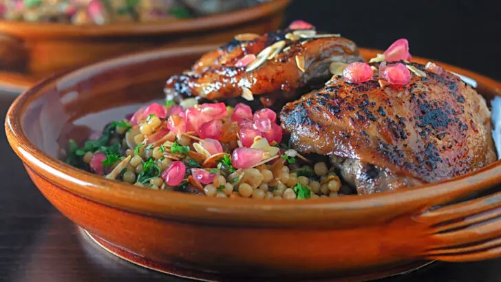 Pomegranate molasses glazed chicken thighs with giant couscous and almonds.