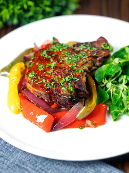 Tray baked paprika pork chop with red wine and honey bell peppers and onions.