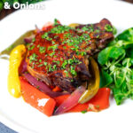 Tray baked paprika pork chop with red wine and honey bell peppers and onions featuring a title overlay.