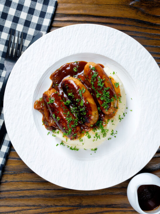 Overhead slow cooker pork sausages in a mustard and BBQ sauce.