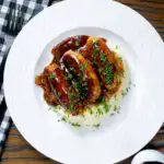 Overhead slow cooker pork sausages in a mustard and BBQ sauce featuring a title overlay.