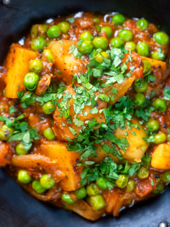 Close-up overhead Indian aloo matar curry with potatoes and peas.