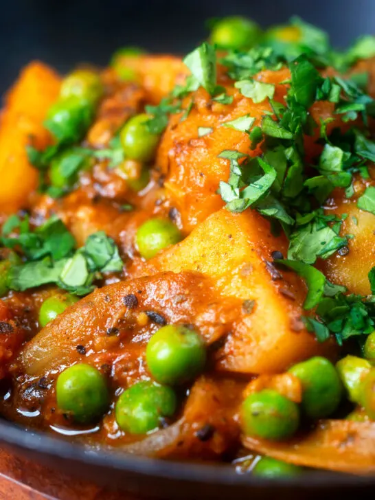 Close-up Indian aloo mutter curry with potatoes and peas.