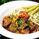 Hungarian birkapörkölt or mutton stew served with nokedli featuring a title overlay.