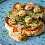 Creamy garlic mushrooms on toast with portobello and button mushrooms and snipped chives.