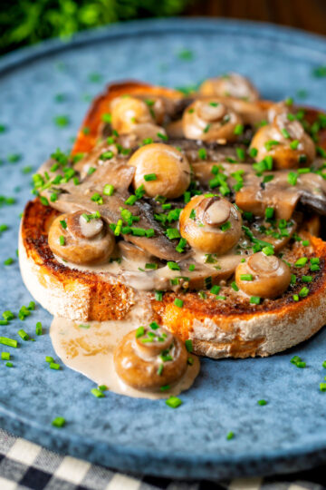 Creamy garlic mushrooms on toast with portobello and button mushrooms and snipped chives.