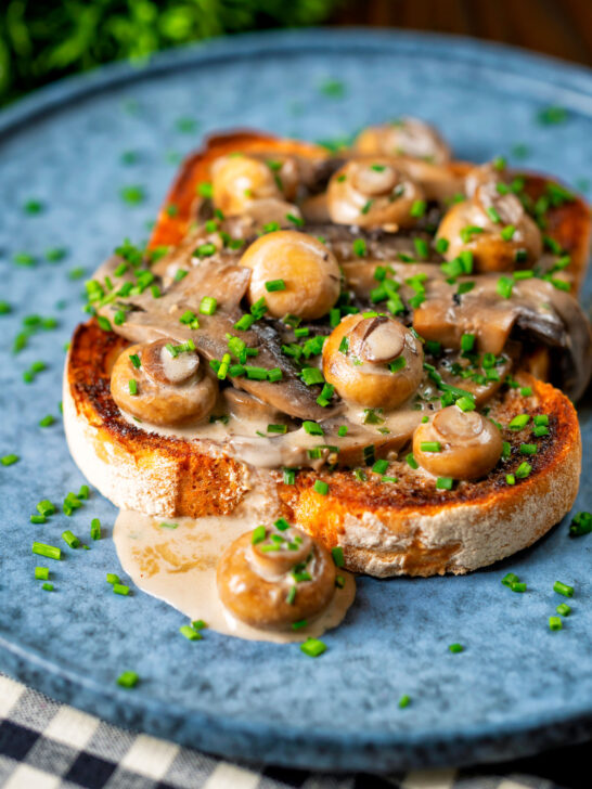 Creamy garlic mushrooms on toast with portobello and button mushrooms and snipped chives.