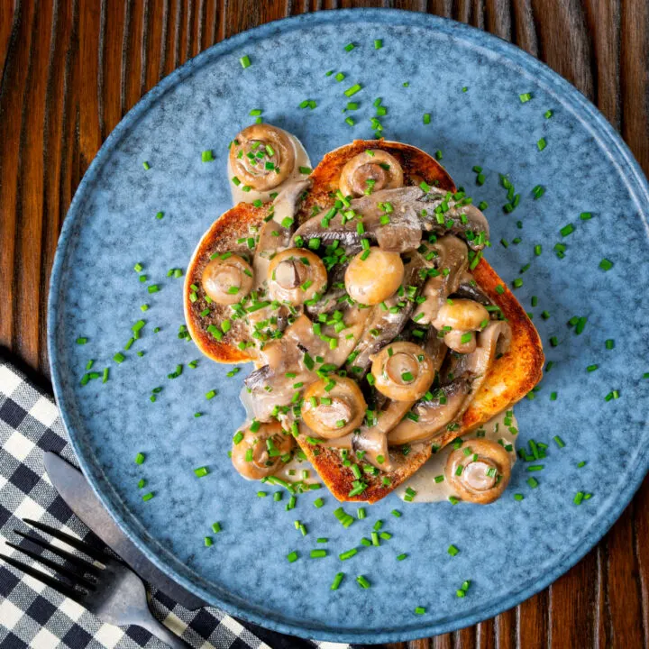 Creamy garlic mushrooms on toast with a brandy cream sauce and snipped chives.