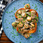 Overhead creamy garlic mushrooms on toast with portobello and button mushrooms and snipped chives.