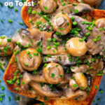 Overhead Close-up creamy garlic mushrooms on toast with snipped chives featuring a title overlay.