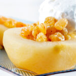 Close-up pudding wine poached pears with golden raisins and Chantilly cream.