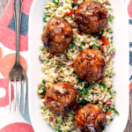 Overhead harissa beef meatballs served with bulgur wheat.