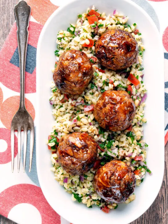 Overhead harissa beef meatballs served with bulgur wheat.