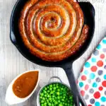 Overhead cooked Cumberland sausage ring with onion gravy, peas and mash featuring a title overlay.