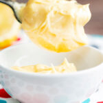 Close up thick and creamy golden mayonnaise on a spoon showing texture.