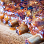 Close-up apple and honey glazed pressure cooker pork ribs featuring a title overlay featuring a title overlay.