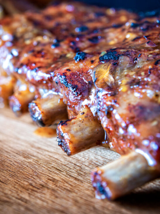 Close-up apple and honey glazed pressure cooker pork ribs featuring a title overlay featuring a title overlay.