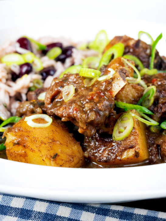 Close-up Jamaican curry goat served with rice and peas.