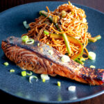 Korean yang nyum inspired grilled salmon fillet served with noodles.