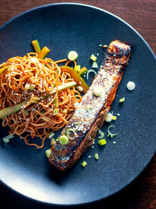 Overhead Korean inspired grilled salmon fillet served with noodles.