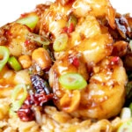 Close-up kung po king prawns with peanuts and egg fried rice.
