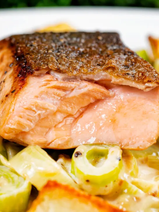Close up pan fried salmon with crispy skin showing internal flesh colour when cooked.