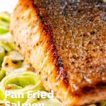 Close up pan fried salmon fillet with crispy skin served with creamed leeks featuring a title overlay.