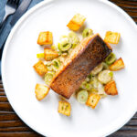 Overhead pan fried salmon fillet with crispy skin served with creamed leeks and parmentier potatoes.
