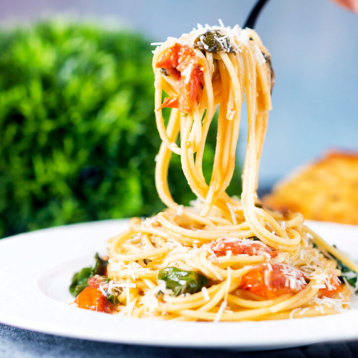 Roasted garlic pasta with tomatoes, wilted spinach and grated parmesan.