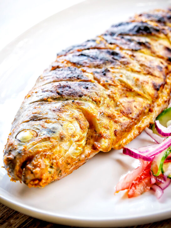 Whole tandoori trout fish that has been cooked on a BBQ.