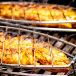 Tandoori trout being cooked on a bbq.