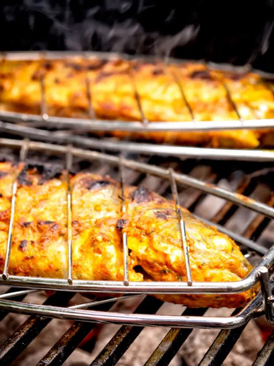 Tandoori trout being cooked on a bbq.