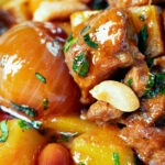 Close-up Thai lamb massaman curry with potatoes, shallots and peanuts.