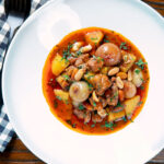 Overhead slow-cooked Thai lamb massaman curry with potatoes, shallots and peanuts.