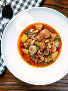 Overhead slow-cooked Thai lamb massaman curry with potatoes, shallots and peanuts.